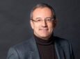 Eutelsat CEO Jean-François Fallacher is pictured in a suit, against a grey background.